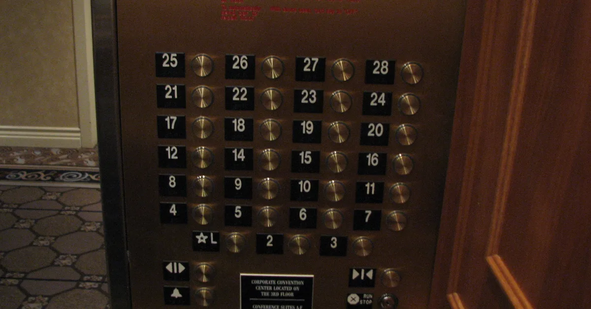 Brass elevator button panel with rows 4 to 7, 8 to 11 and 12, 14, 15, 16, and no button for 13
